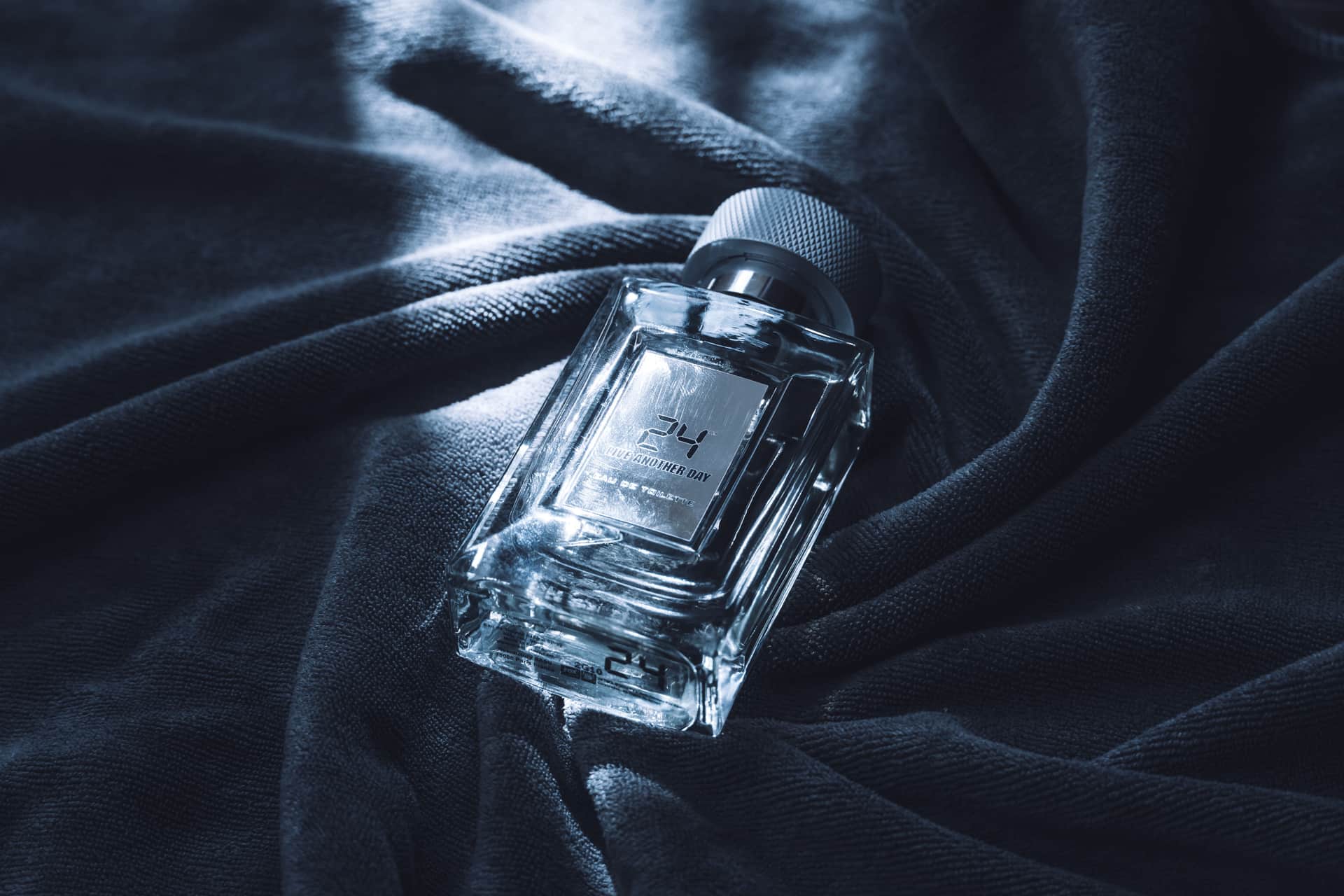 A single cologne bottle on a moody, warm-lit surface